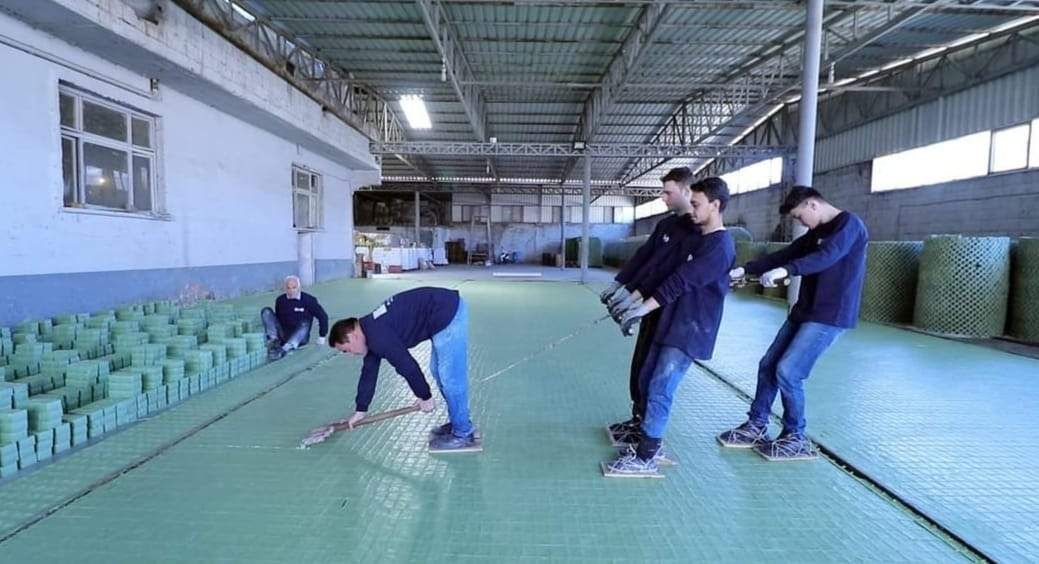 Craftsmen cutting the soap sheet into a grid of bars